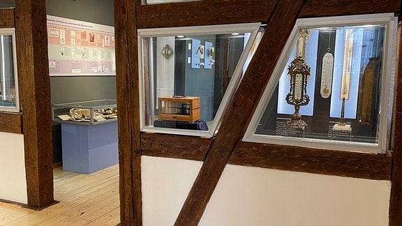 Thermometermuseum, Fachwerkwände, in die Balken eingelassen sind Vitrinen mit Ausstellungsstücken.