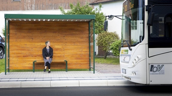 Eine Frau wartet auf einen Bus