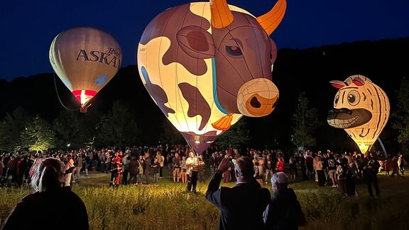 Ballonglühen im Viba-Park in Schmalkalden: Heißluftballons fliegen über einer Menschenmenge los.