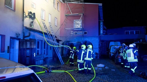 Feuerwehrleute vor einem Haus.