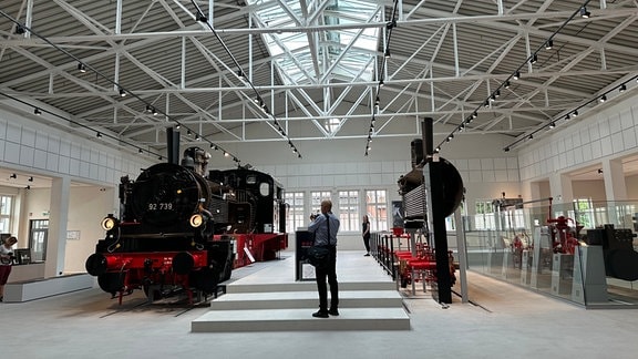 Ein Mann fotografiert eine Dampflok in der Dampflok-Erlebniswelt in Meiningen.