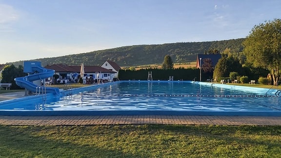 Wasserbecken im Freibad Kaltennordheim mit Blick auf das angrenzende Waldgebiet