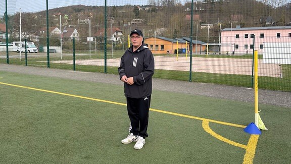 Trainer Jürgen Herbst steht auf Sportplatz.