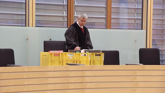 Ein Richter mit Akten in einem Gerichtssaal.
