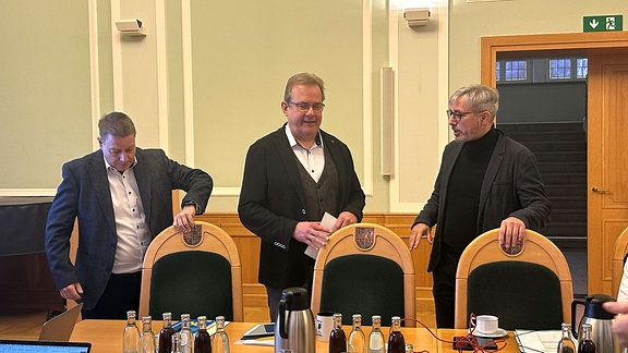 Bürgermeister André Henneberg, André  Knapp (CDU) und Richard Rossel (pl) stehen an einem Tisch.