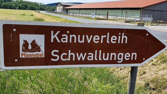 Schild "Kanuverleih Schwallungen" bei Straße.