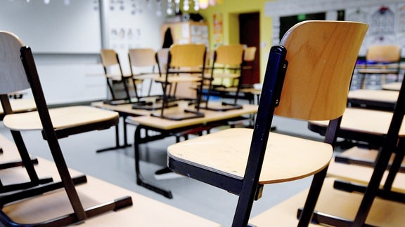 Stühle stehen im Klassenraum einer Grundschule auf den Tischen
