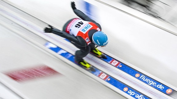 Skispringer auf der Schanze, Ski tragen den Schriftzug "fluege.de"