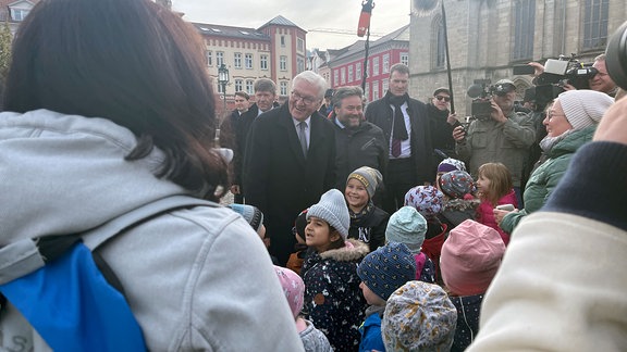 Bundespräsident Frank-Walter Steinmeier neben einer Gruppe Kinder in Meiningen.