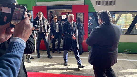 Bundespräsident Frank Walter Steinmeier lauft mit ausgestreckter Hand auf Meiningens Bürgermeister Fabian Giesder zu.