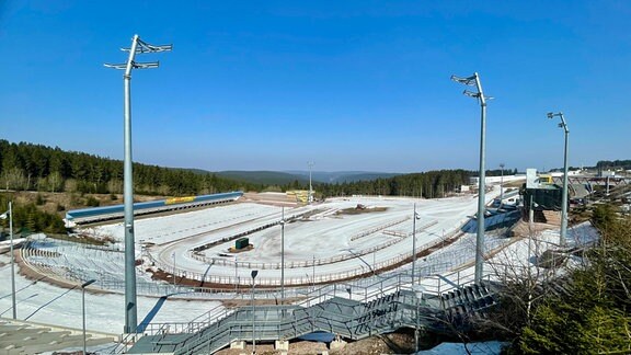 Blick von oben ins Biathlon-Stadion in Oberhof. Im Stadion liegt noch eine Schneedecke.