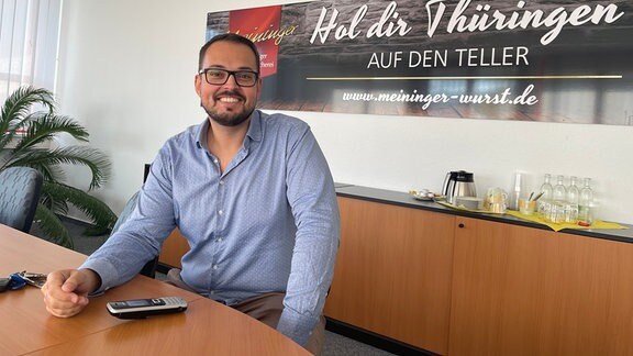 Alexander Voigt, Geschäftsführer der Meininger Wurstspezialitäten am Tisch 