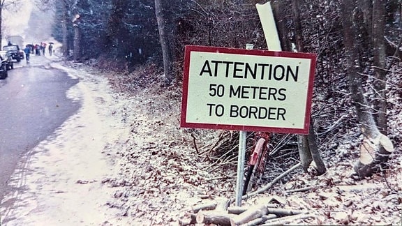 Altes Foto von einem Schild im Winter mit Aufschrift "Attention 50 meters to border"