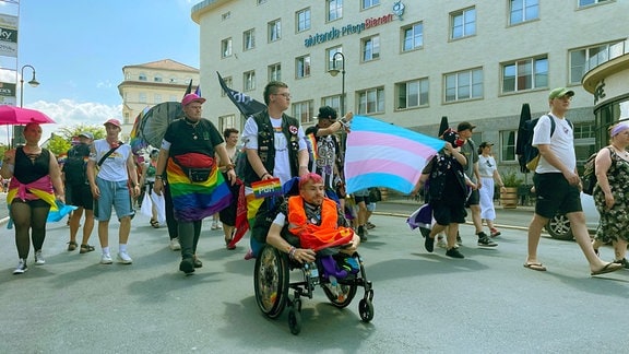 Menschen mit Regenbogenfahnen ziehen durch die Sonneberger Innenstadt