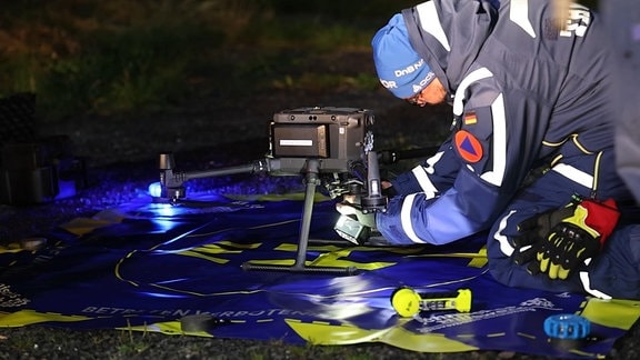 Ein Mitarbeiter des Technischen Hilfswerk macht eine Wärmebilddrohne startklar.