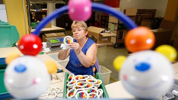 Eine Frau fertigt Spielzeug.