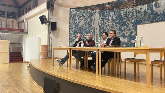 Vier Männer sitzen auf einem Podium an einem Tisch, darunter Sonnebergs Landrat Robert Sesselmann (AfD)
