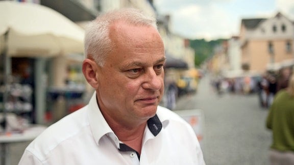 Der CDU-Landratskandidat Jürgen Köpper steht in einer Fußgängerzone in Sonneberg.