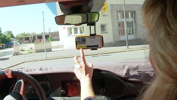 Ein Smartphone an der Windschutzscheibe eines Autos