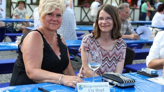 Zwei Frauen sitzen an einem Tisch.