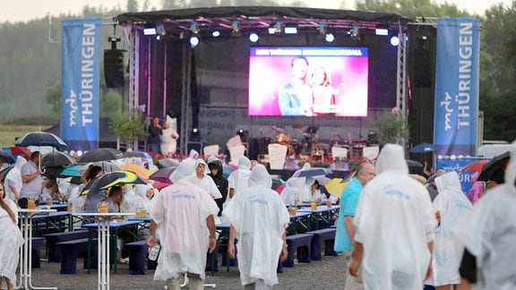 Publikum in Regenkleidung vor der Bühne