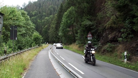 Autos und Motorräder fahren auf einer Landstraße