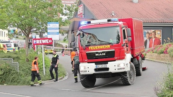 Ein Feuerwehr-Auto rollt von einem Supermarkt-Parkplatz in Suhl.