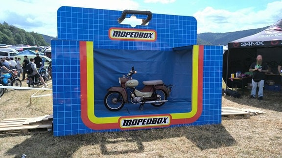 Ein Simson-Moped in einer riesigen Spielzeugverpackung