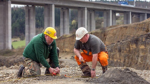 Die Sprengmeister Frank Leder (l) und Mike Schubert verkabeln am 05.04.2016 neben der A71-Autobahnbrücke Schindgraben bei Meiningen (Thüringen) Sprengstoff für die planmäÃige Sprengung von 20.000 Tonnen Kalkstein im darunterliegenden Steinbruch.