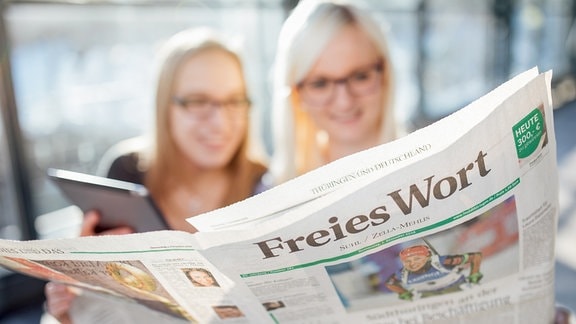 Zwei Frauen betrachten am 26.01.2017 in Suhl ( Thueringen ) die App " insuedthueringen " auf einem Tablet und die Printausgabe der Tageszeitung " Freies Wort ".