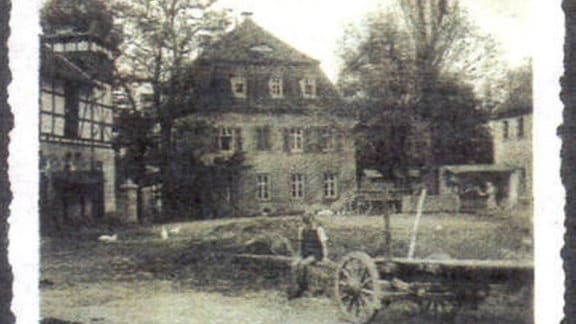 Ein historisches Foto des Rittergut Endschütz. Im Vordergrund ein kleiner Junge auf einem Leiterwagen