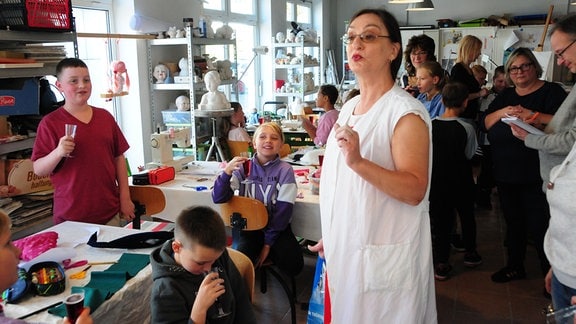 Regina Trutzl aus Sonneberg in ihrem Atelier zusammen mit Kindern und Gästen.
