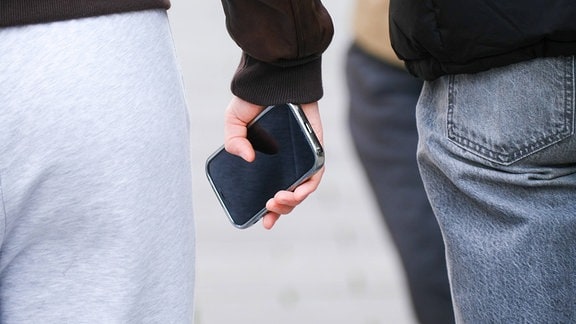 Eine Person hält ein Handy in der Hand