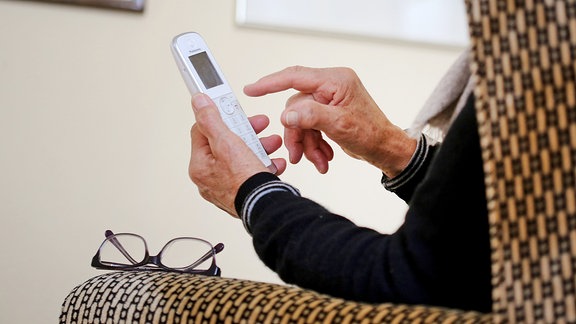 Eine Person hält ein Telefon in der Hand