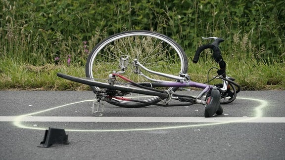 Ein Rennrad liegt nach einem Unfall auf der Straße