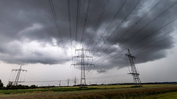 Dunkle Wolken eines Gewitters über Stromleitungen
