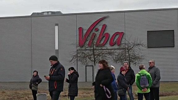 Eine Gruppe Menschen steht vor einem Gebäude der Firma Viba