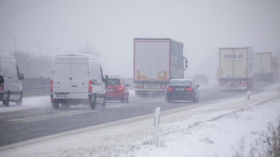 Fahrzeuge auf einer verschneiten Autobahn.