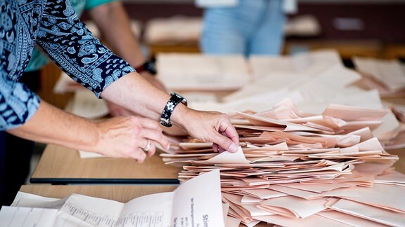 Eine Wahlhelferin sortiert Stimmzettel