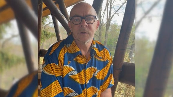 Mann mit Brille und buntem Hemd