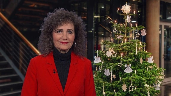 Birgit Pommer steht vor einem Weihnachtsbaum.