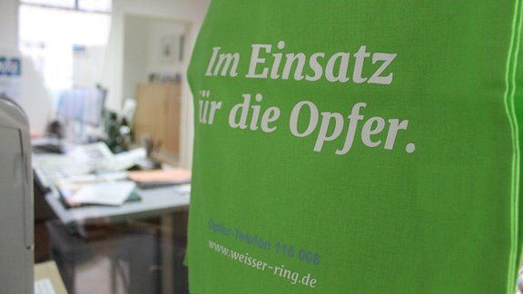 ein grüner Stoffbeutel mit der Aufschrift "Im Einsatz für die Opfer"