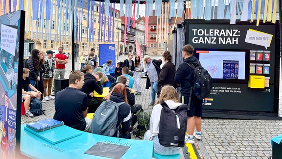  Schüler auf einem Platz in Eisenach vor einer Ausstellung.