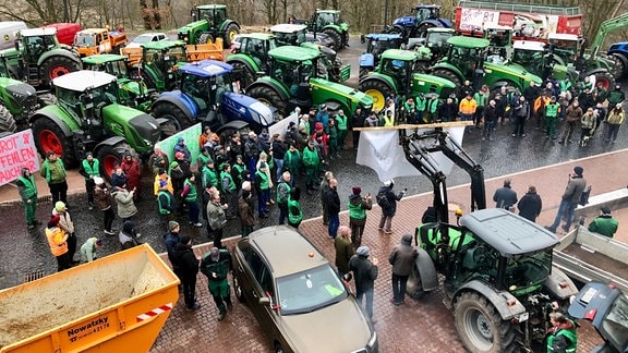 Mehrere Traktoren und Menschen protestieren auf dem Parkplatz der Wartburg.