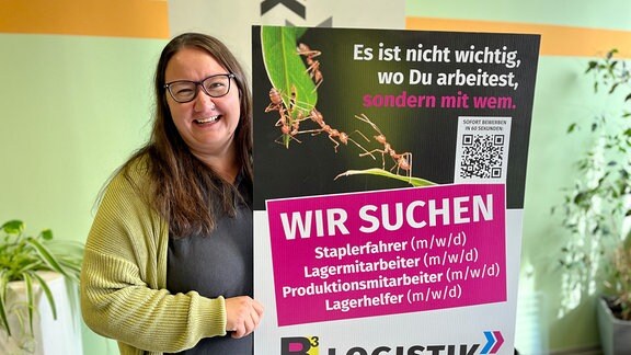 Franziska Pfau vom Logistikunternehmen BCUBE hält ein Plakat