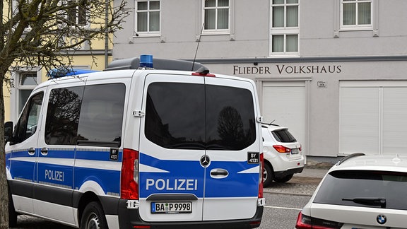 Ein Polizeifahrzeug steht vor dem "Flieder Volkshaus", das von der Polizei durchsucht wurde.
