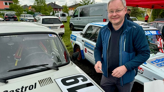 Technische Abnahme zur 60. Rallye Wartburg Eisenach: ein Mann zwischen PKW bei der Rennvorbereitung