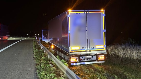 Lkw nach Unfall hinter einer Leitplanke