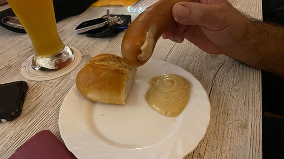 eine Bockwurst mit Send auf einem Pappteller