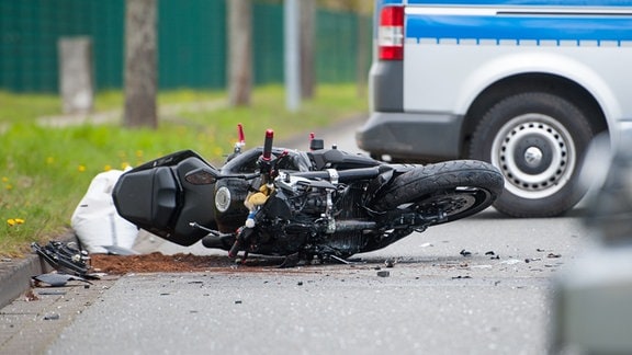 Ein Motorrad liegt nach einem Zusammenstoß mit einem Auto auf der Straße.